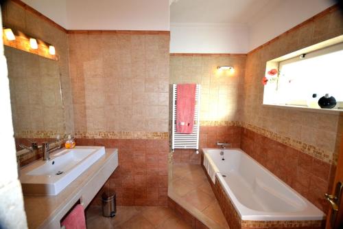 Un baño con dos lavabos y una bañera. en Villa Vida Nova, en Monchique