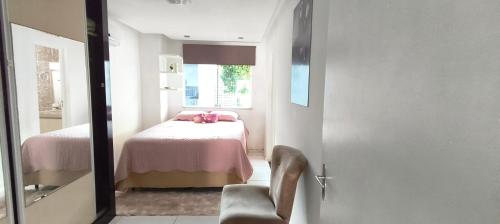 une chambre avec un lit et une chaise dans une pièce dans l'établissement BEACH HOUSE ARUANA, à Aracaju