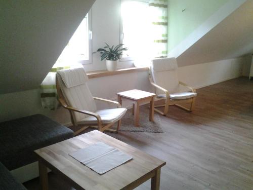 a living room with two chairs and a table at Lütt Gammelby in Gammelby