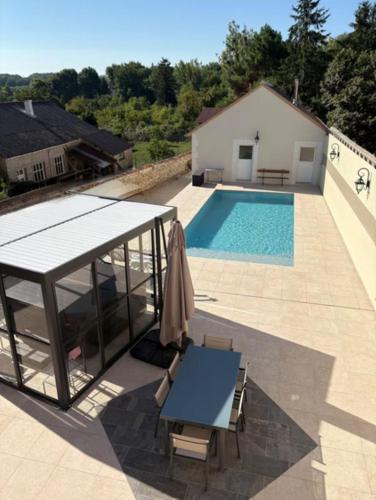 eine Terrasse mit Tisch und Swimmingpool in der Unterkunft Jolie maison 6 pers spa privé wifi 14 km Beauval in Meusnes