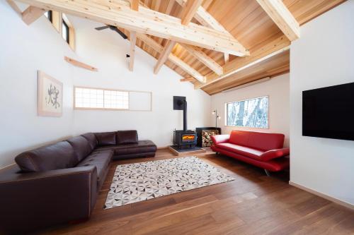 a living room with a couch and a fire place at Asagiri Chalet Hakuba in Hakuba