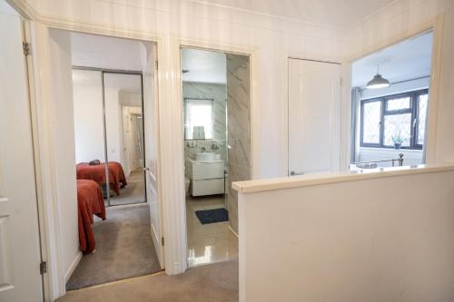 a bathroom with a sink and a bed and a mirror at Carey House Long Stays Free Parking and WI-FI in Swindon