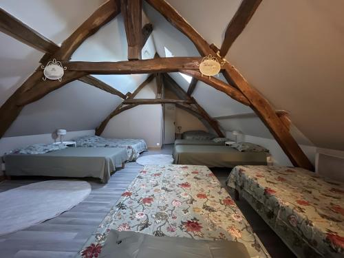 Cette chambre mansardée comprend 3 lits. dans l'établissement Le Gué De La Terre, à Saint-Viâtre