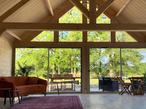 un salon avec un canapé et une grande fenêtre dans l'établissement Le Gué De La Terre, à Saint-Viâtre