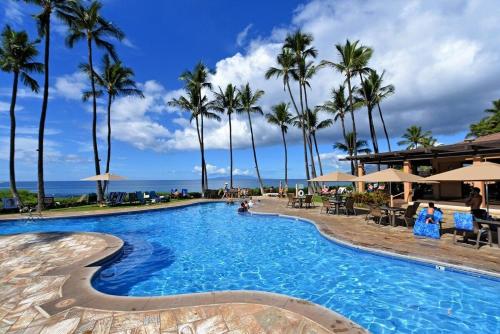 a swimming pool with palm trees and the ocean at Wailea Ekahi 17D · WEK 17D Wailea Retreat w Ocean View Pool AC in Wailea