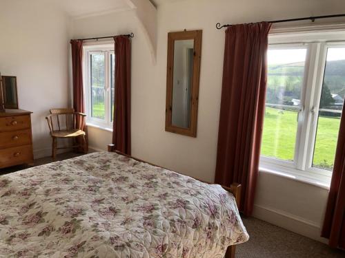 een slaapkamer met een bed, een spiegel en ramen bij 4 Bed in Stokenham oc-i34021 in Stokenham