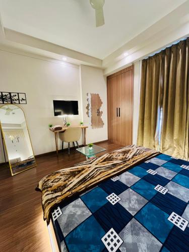 a room with a bed and a desk in it at Sixty one stays in Greater Noida