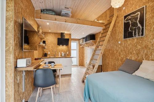 Habitación con cama, escritorio y cocina. en Small Oasis Near Coast And Town, en Ebeltoft