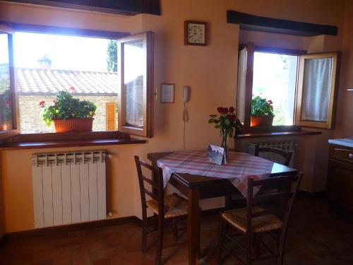 a dining room with a table and chairs and two windows at Magnolia in Pratovecchio