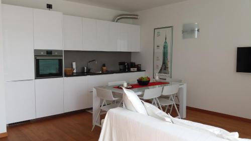 利多迪迪耶索洛的住宿－Apartment Mare e Laguna，厨房配有白色橱柜和桌椅