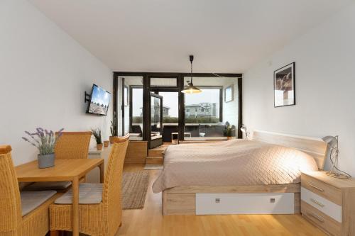 a bedroom with a bed and a desk and a table at Marina Wendtorf Hafenblick in Wendtorf