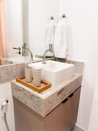 a bathroom sink with two candles on a wooden tray at Refugio a 50 passos do mar in Tamandaré