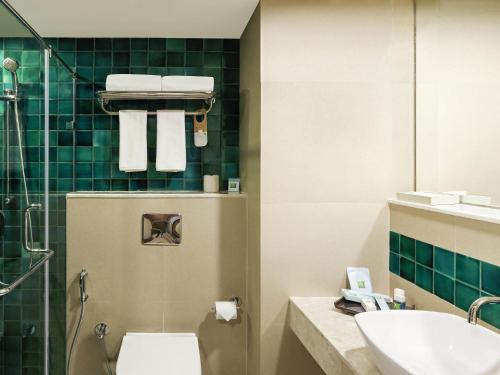 a bathroom with a toilet and a sink at ibis Styles Goa Calangute - An Accor Brand in Calangute