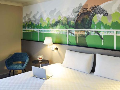 黑多克黑多克美居酒店 的酒店客房,配有一张带笔记本电脑的床