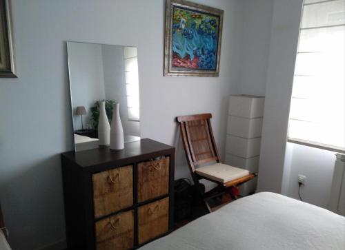 una camera da letto con cassettiera, specchio e sedia di Villa La Perla De Sonabia a Oriñón