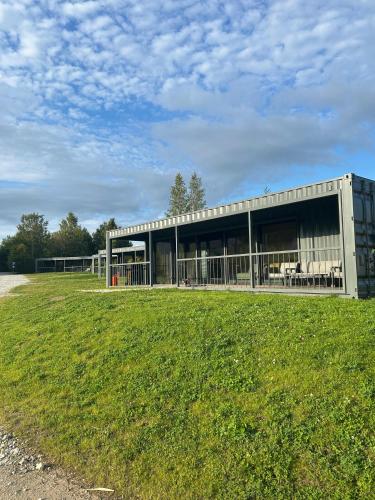 a building with a grass field in front of it at Rummu Holiday Home in Rummu