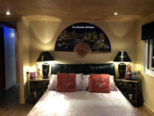 a bedroom with a large bed with two lamps at Have tonights dreams wrapped in Chinese silk in Swansea