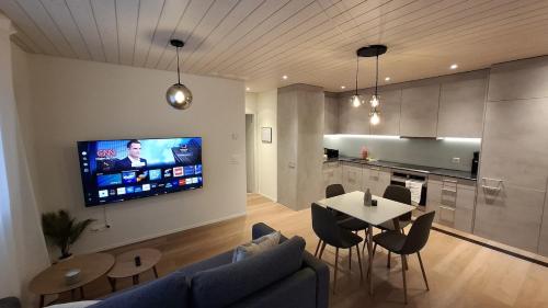 Una sala de estar con una mesa y un televisor en una pared. en Mountain view with balcony and free parking, en Lungern