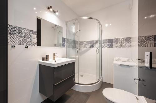 a bathroom with a shower and a sink and a toilet at Flatbook - City Center Comfort Studio in Gdańsk