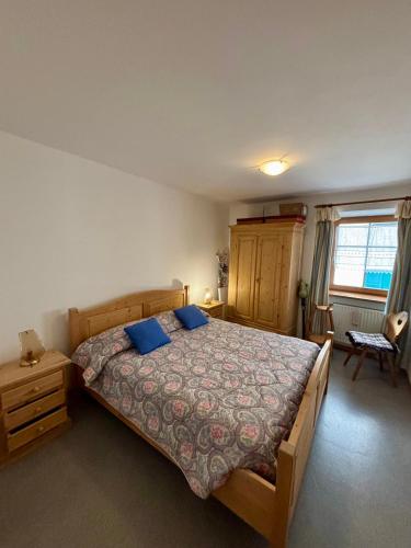 a bedroom with a large bed with blue pillows at Pragma Apartments - Casa Defrancesco in Cavalese
