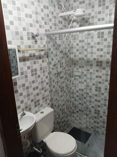 a bathroom with a toilet and a sink at Mini Casarão in São Bento do Sapucaí