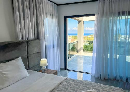 a bedroom with a bed and a large window at Suya Studios by HolidayKeys in Karavas