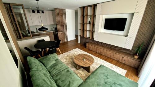 尼什Fluvius Suite - Riverside Elegance in the Heart of Niš with Free Parking的客厅里有一张沙发和一张桌子。