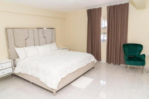 1 dormitorio con 1 cama grande y 1 silla verde en La Isla Royal - Abismo Celeste, en Miches