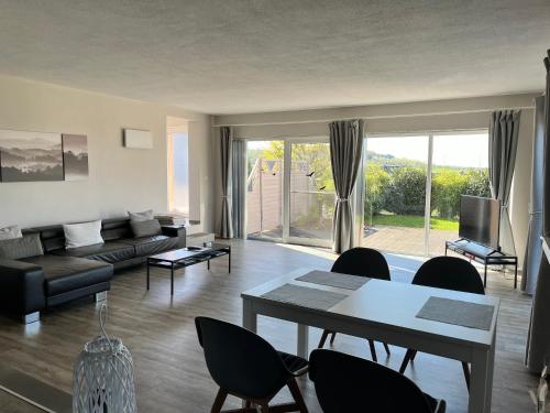 ein Wohnzimmer mit einer Couch und einem Tisch und Stühlen in der Unterkunft Ferienwohnung mit Terrasse und eigenem Garten in Ortsrandlage in Hartenfels