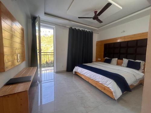 una camera con un grande letto e un ventilatore a soffitto di A Hotel & Restaurant a Mussoorie