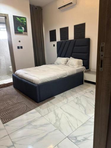 a bedroom with a bed with a blue headboard at Primefix in Lekki