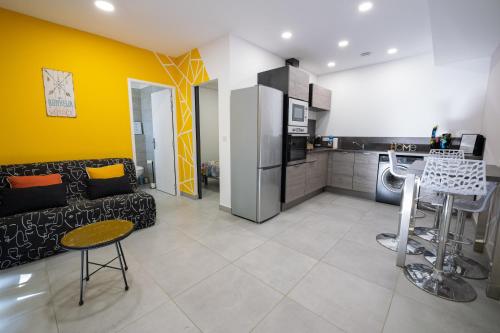 a living room with a couch and a kitchen at N10 Maison T2 climatisé avec jacuzzi privé in Ajaccio