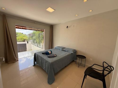 ein Schlafzimmer mit einem Bett und einem großen Fenster in der Unterkunft Village GRAND LUX exclusivo com piscina privativa in Feira de Santana