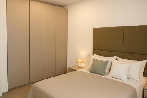 a bedroom with a bed with white and green pillows at Al GrattacieloTrenta in Verona