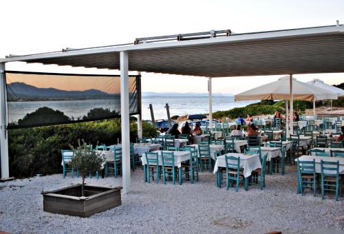 a restaurant with tables and chairs and a view of the ocean at Villa Serenity in Porto Rafti