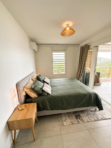 - une chambre avec un lit vert et une table dans l'établissement Appartement Madinina View, à Fort-de-France