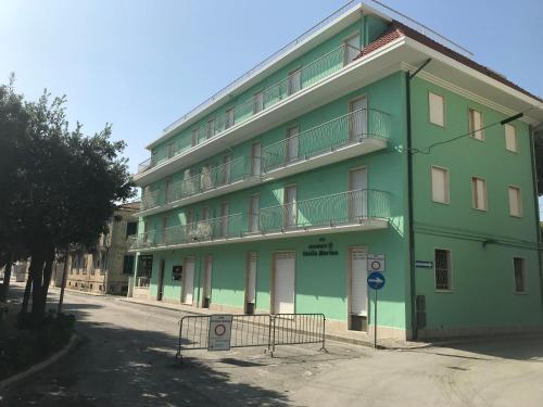 ein grünes Gebäude mit Balkon auf der Seite in der Unterkunft Ferienwohnung in Cupra Marittima mit Terrasse und Garten in Cupra Marittima