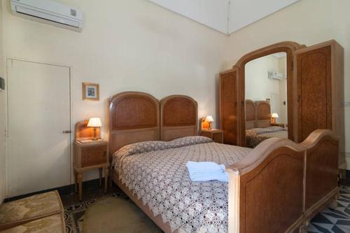 ガラトーネにあるIl Giardino casa vacanzeのベッドルーム1室(木製ベッド2台、鏡付)