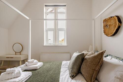 a white bedroom with a bed and a window at Perfect Base for Work or Leisure Unique Two-Bed in Irlam