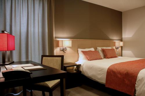 ein Hotelzimmer mit einem Bett und einem Schreibtisch in der Unterkunft Relais de L'Empereur in Genappe