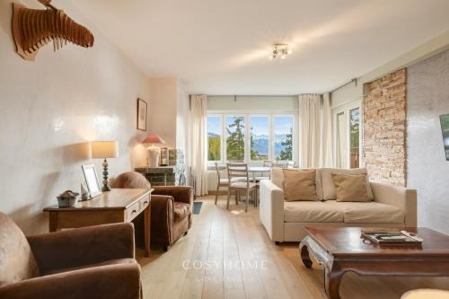 a living room with a couch and a table at Alpine Sunset l Attique l Golf l By CosyHome in Crans-Montana