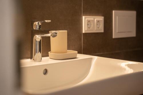 La salle de bains est pourvue d'un lavabo et d'un robinet. dans l'établissement Riversidesuite-Tuebingen, à Tübingen