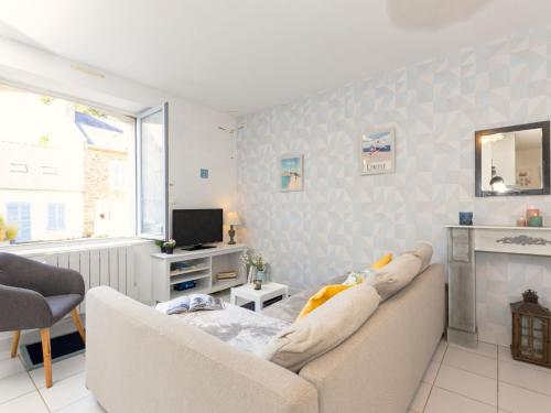 a living room with a couch and a television at Holiday Home Le Nid de Cancale by Interhome in Cancale