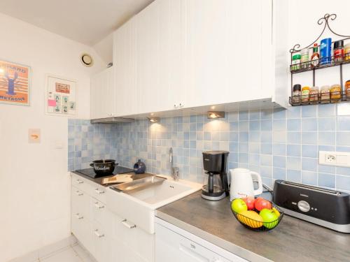 a kitchen with a sink and a bowl of fruit on the counter at Holiday Home Le Nid de Cancale by Interhome in Cancale