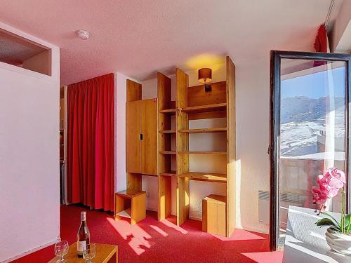 a room with a book shelf and a red curtain at Studio Les Olympiades-23 by Interhome in Val Thorens