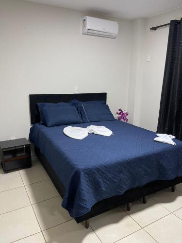 a bedroom with a blue bed with two towels on it at Manancial Hotel in Paracatu