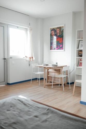 a living room with a table and chairs and a window at Costa Cabral Porto Flat in Porto
