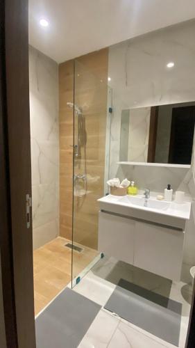 a bathroom with a sink and a glass shower at Cozy apartment in Kenitra