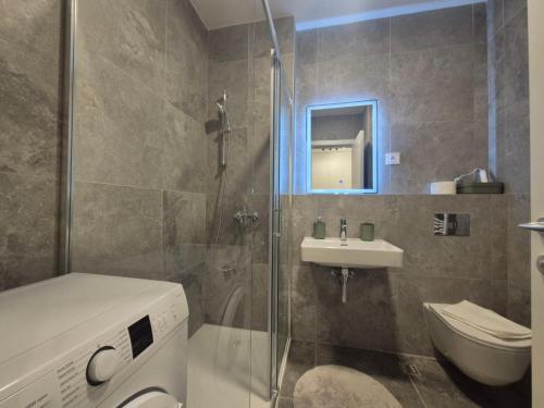 a bathroom with a toilet and a sink and a shower at Lastavica residence, modern luxury apartment with free garage in Novi Beograd