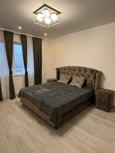 a bedroom with a large bed and a large window at Millo Apartament in Bucharest